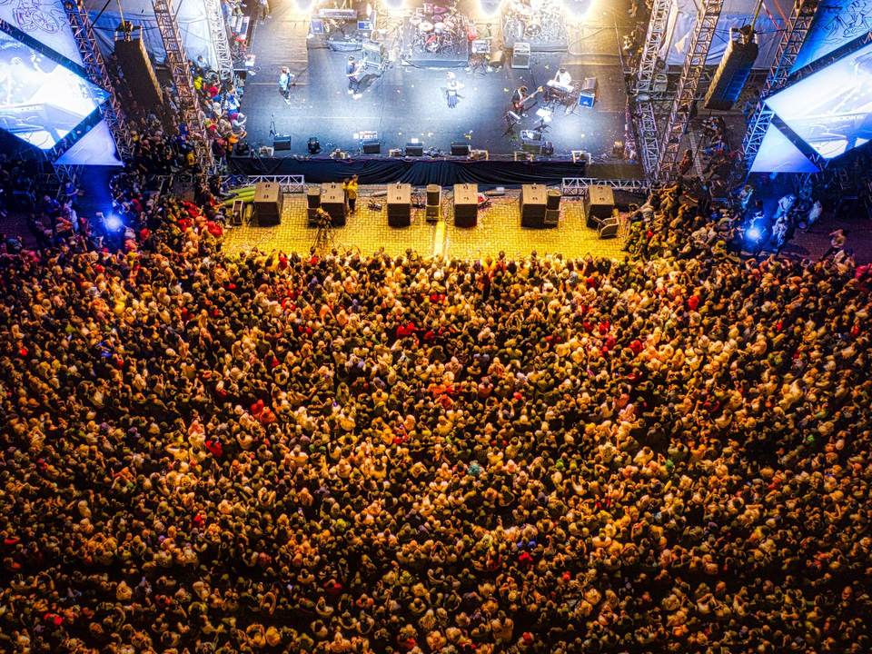 Aerial view of a packed crowd in front of a festival stage